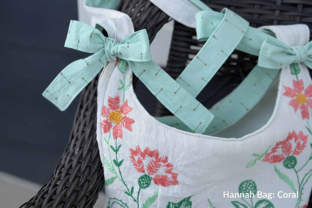 Floral embroidered fabric with a green bow tied around it, against a dark background.
